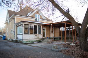 View of front of house featuring roof with shingles and a sunroom