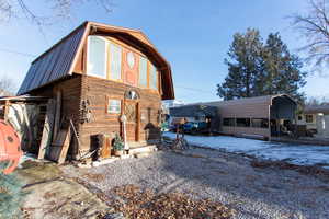 Snow covered property with a gambrel roof and a metal roof