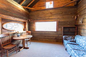 Living area featuring carpet flooring, lofted ceiling, and plenty of natural light
