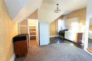 Bonus room featuring wallpapered walls and lofted ceiling
