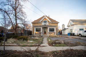 Bungalow-style home featuring a chimney and roof with shingles