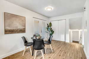 Dining room with french doors, light wood finished floors, and a textured ceiling