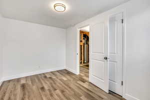 Unfurnished room with light wood-style flooring and baseboards