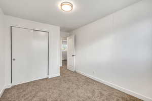 Unfurnished bedroom with a closet and carpet flooring