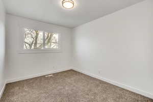 Unfurnished room with carpet flooring and baseboards