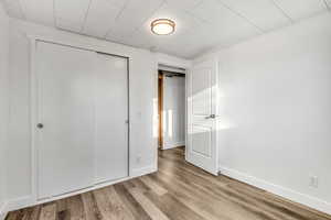 Unfurnished bedroom featuring wood finished floors and a closet
