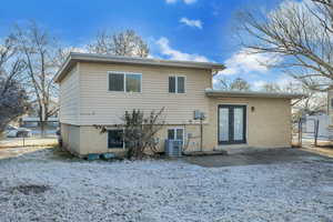 Snow covered property featuring french doors, brick siding, and a gate