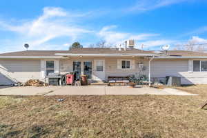 Back of house featuring a patio area, a yard, and a shingled roof