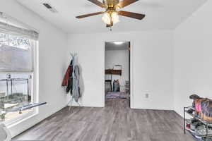 Unfurnished room with wood finished floors and a ceiling fan