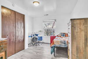 Bedroom featuring a closet and light wood-style flooring