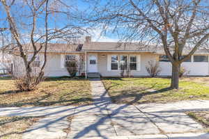 Ranch-style home with a chimney and a front yard