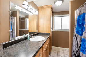Full bath featuring a shower with shower curtain and vanity