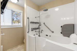 Full bath featuring light floors, a textured ceiling, and shower / bathtub combination