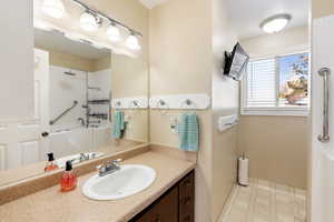 Full bath with light flooring and vanity