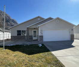View of front of property with brick siding, driveway, an attached garage, and a mountain view