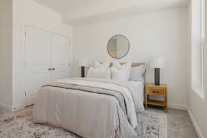 Carpeted bedroom with baseboards and a closet