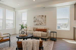 Living area with wood finished floors and recessed lighting