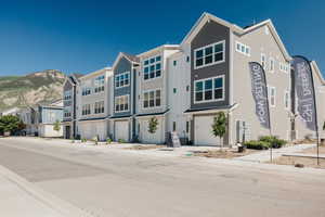 View of front facade with a residential view, an attached garage, and a mountain view