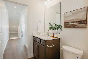 Bathroom featuring vanity, recessed lighting, and wood finished floors