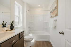 Full bath with vanity, bathing tub / shower combination, and light wood-type flooring