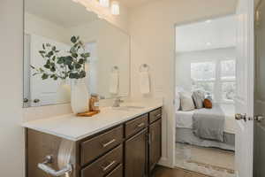Ensuite bathroom with vanity and dark wood-style flooring