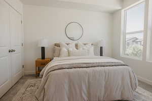 Carpeted bedroom with a closet and baseboards