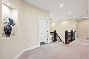 Carpeted empty room with recessed lighting and baseboards