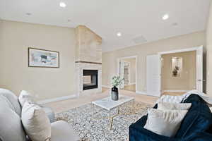 Carpeted living room with a tile fireplace, vaulted ceiling, and recessed lighting