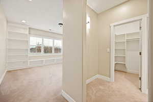 Corridor with light carpet and baseboards