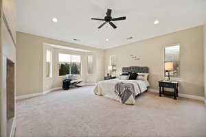 Bedroom with light colored carpet, a ceiling fan, recessed lighting, and a fireplace