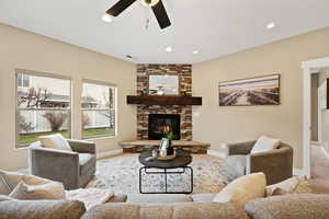 Living area with a fireplace, a ceiling fan, and recessed lighting