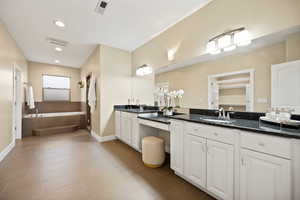 Full bathroom with a bath, double vanity, and recessed lighting