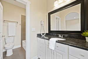 Bathroom featuring vanity, shower / bath combination, and light tile patterned flooring