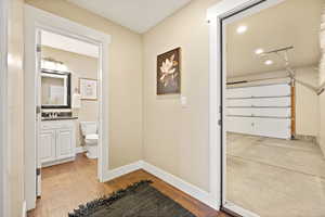 Corridor with light wood-type flooring and recessed lighting