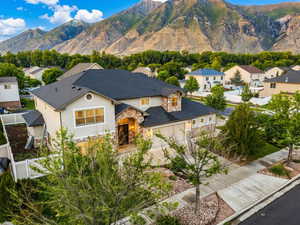 View of front of home featuring stone siding, concrete driveway, a residential view, and stucco siding