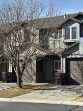 View of front facade featuring concrete driveway and stone siding
