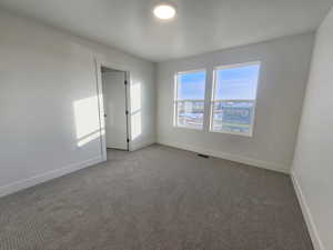 Carpeted spare room with baseboards