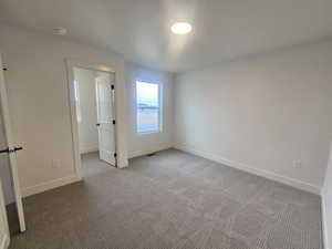 Unfurnished bedroom featuring carpet flooring and baseboards