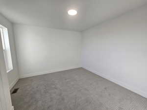 Empty room with carpet floors and baseboards