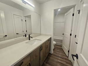 Full bath with vanity, dark wood finished floors, and bathing tub / shower combination
