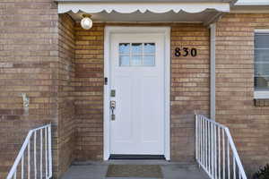 Doorway to property featuring brick siding