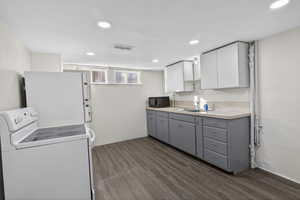Kitchen featuring dual tone cabinets, white appliances, recessed lighting, dark wood-style floors, and light countertops