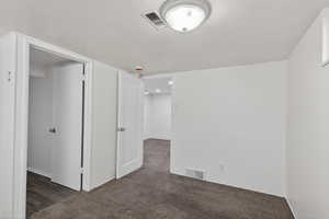 Spare room featuring dark colored carpet