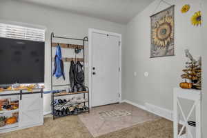 Foyer with light tile patterned floors and baseboards