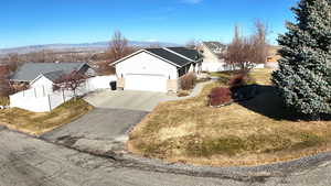 View of front of property with driveway, a garage, and a mountain view