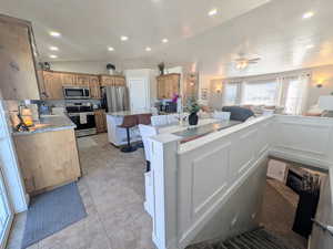 Kitchen featuring open floor plan, a kitchen breakfast bar, a center island, stainless steel appliances, and tasteful backsplash