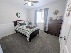 Bedroom featuring carpet, a ceiling fan, and a textured ceiling