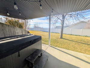 Fenced backyard with a hot tub and a patio