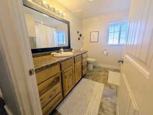 Bathroom featuring a shower with curtain, vanity, and healthy amount of natural light