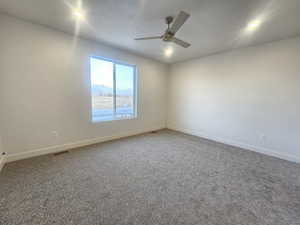 Empty room with carpet floors, ceiling fan, a mountain view, and recessed lighting